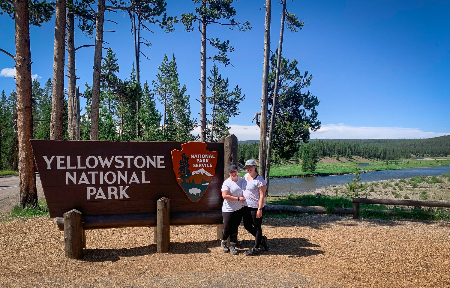 LGBTQ couple in front of Yellowstone sign