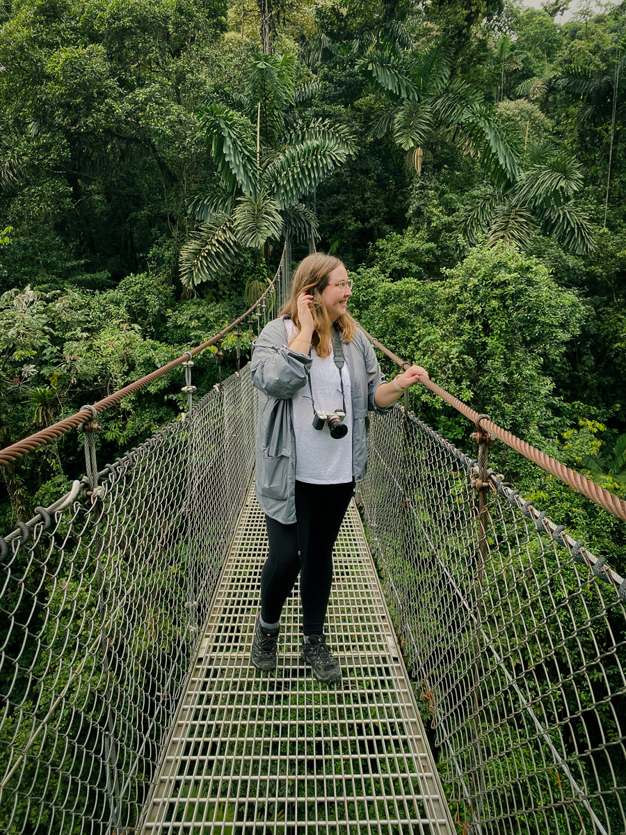 Female photographer standing on a hanging bridge