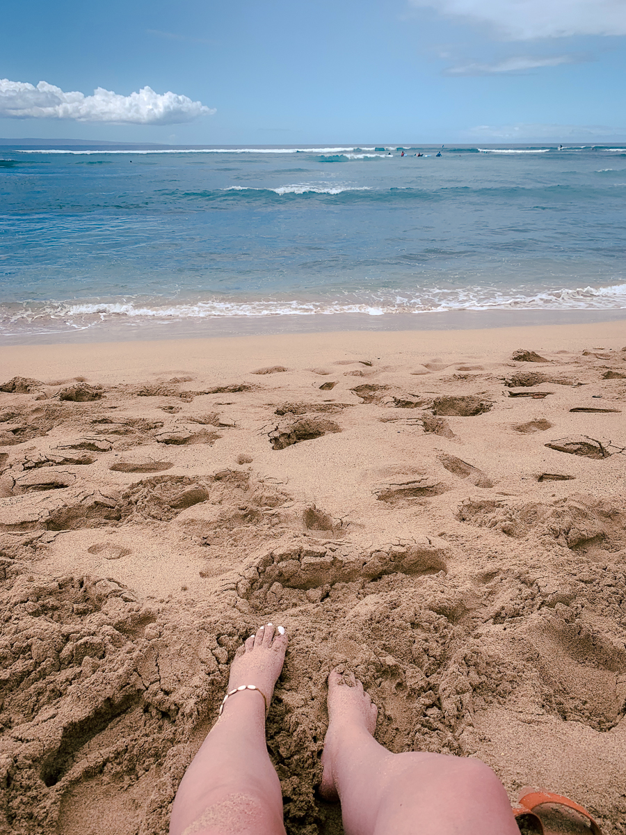 First person view of laying in the sand at the beach