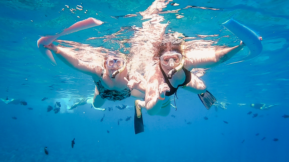 Two women snorkeling underwater at Molokini crater