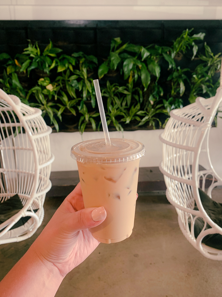 Iced coffee against plant backdrop at Akamai coffee