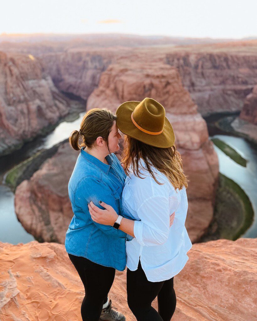 two women kissing at horseshoe bend on grand circle road trip itinerary