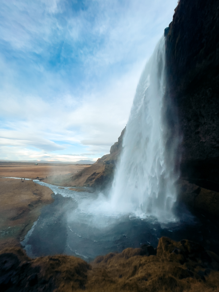 View behind large Seljalandsfoss Waterfall on Iceland five day ring road itinerary